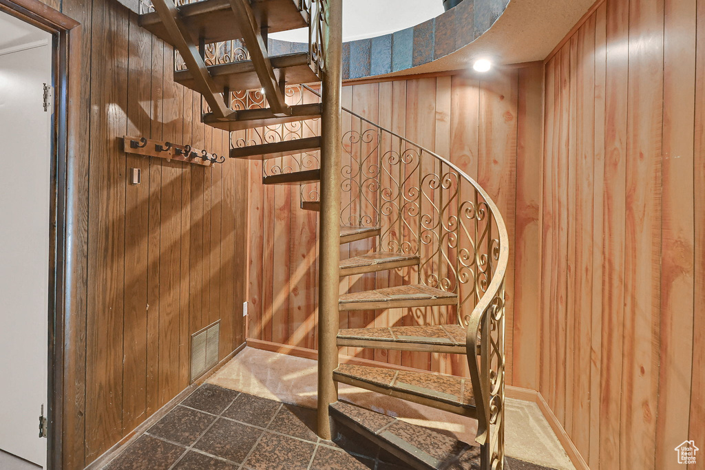 Staircase featuring wood walls