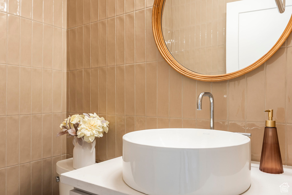 Bathroom featuring tile walls and vanity