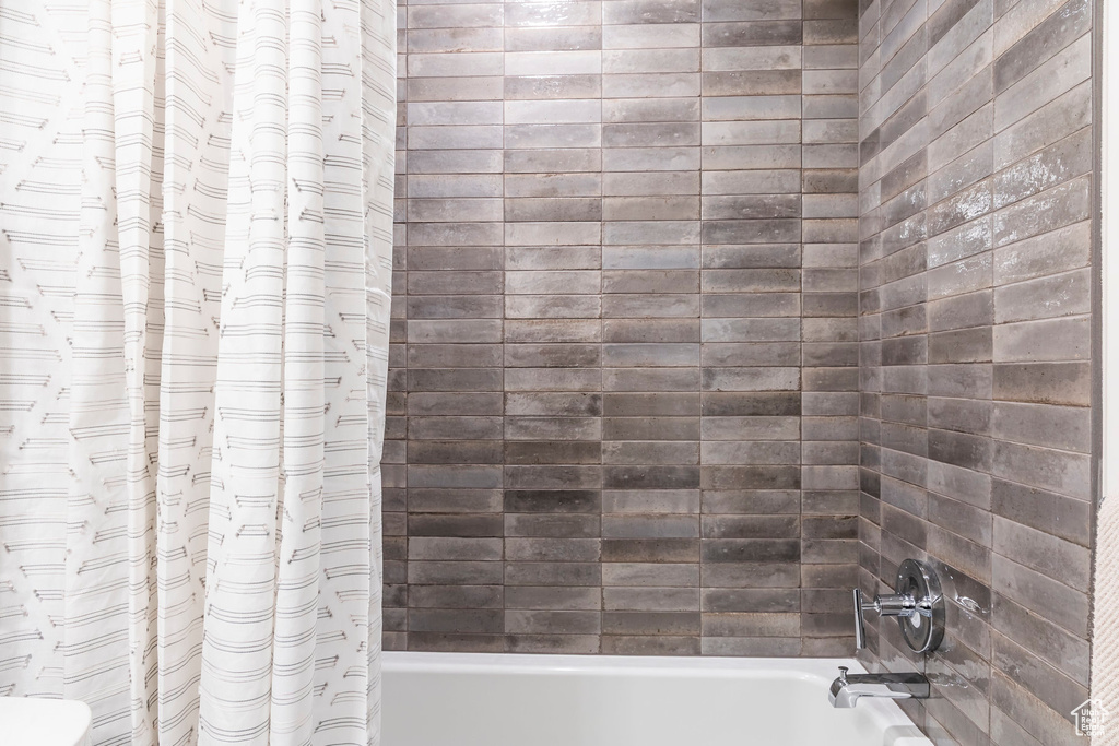 Full bath featuring shower / bathtub combination with curtain and toilet