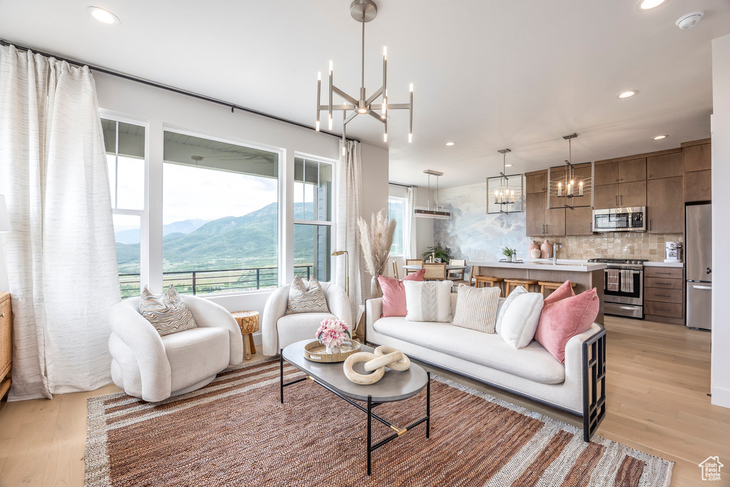 Living area featuring a chandelier, a mountain view, light wood-type flooring, and recessed lighting