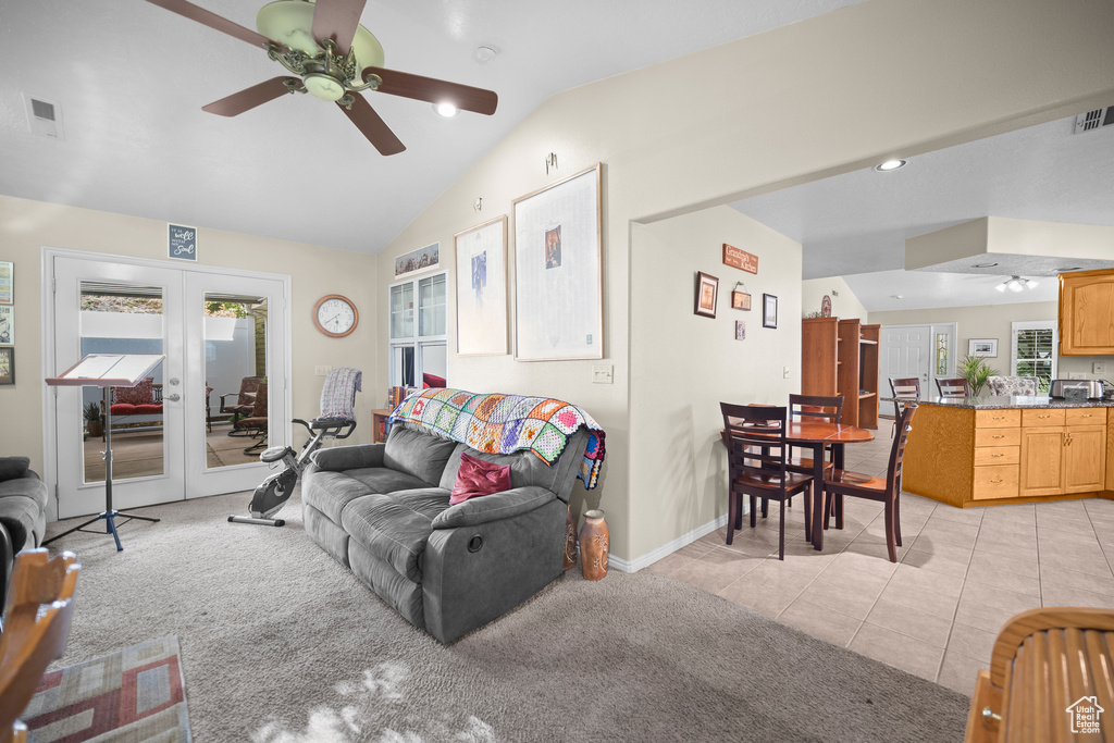 Living room with lofted ceiling, a ceiling fan, french doors, plenty of natural light, and light colored carpet