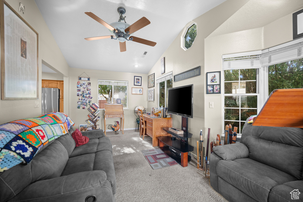 Living area with carpet, a ceiling fan, healthy amount of natural light, and high vaulted ceiling