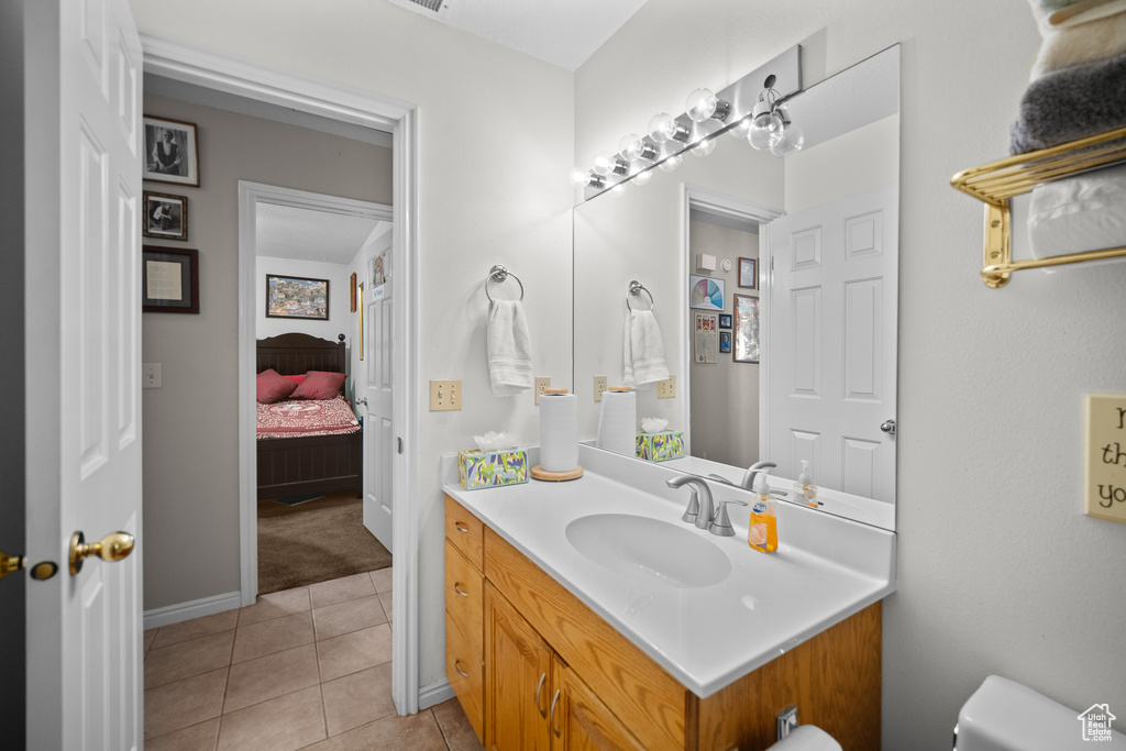 Ensuite bathroom featuring vanity and tile patterned floors