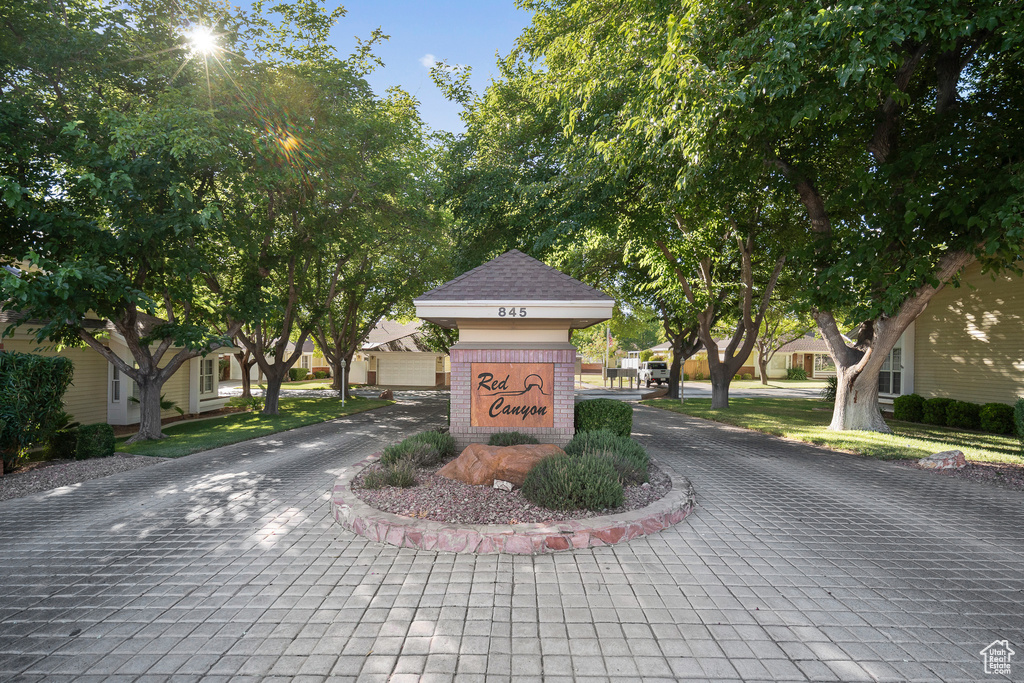 Community sign with decorative driveway and a residential view