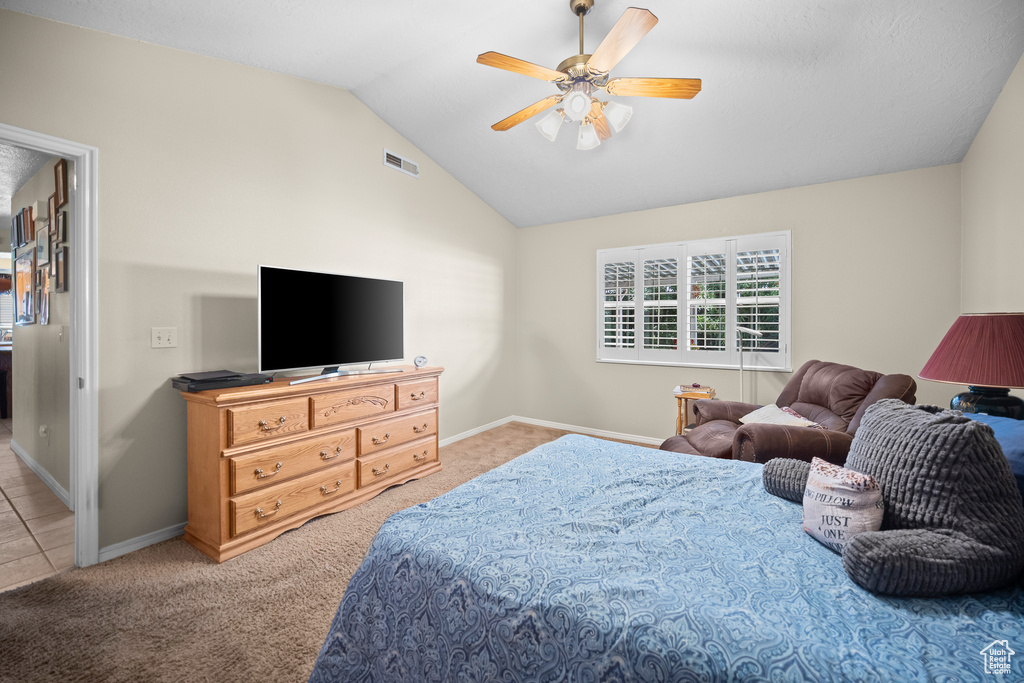 Carpeted bedroom featuring lofted ceiling and a ceiling fan