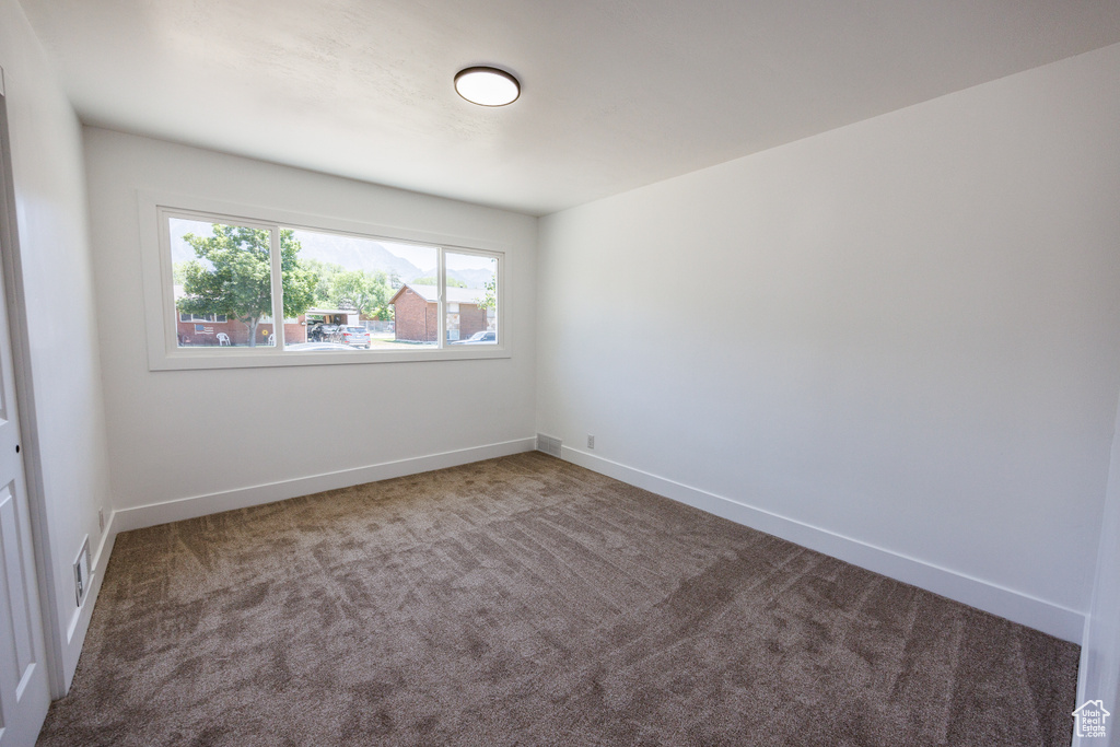 Empty room featuring carpet flooring and baseboards