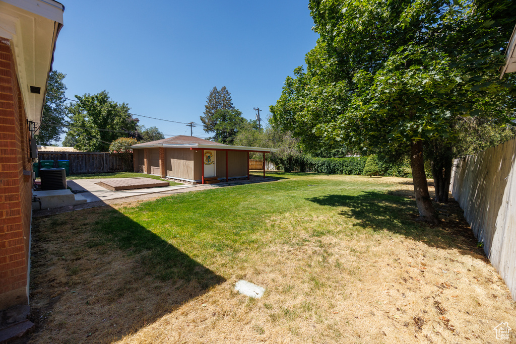 Fenced backyard with an outbuilding and a deck