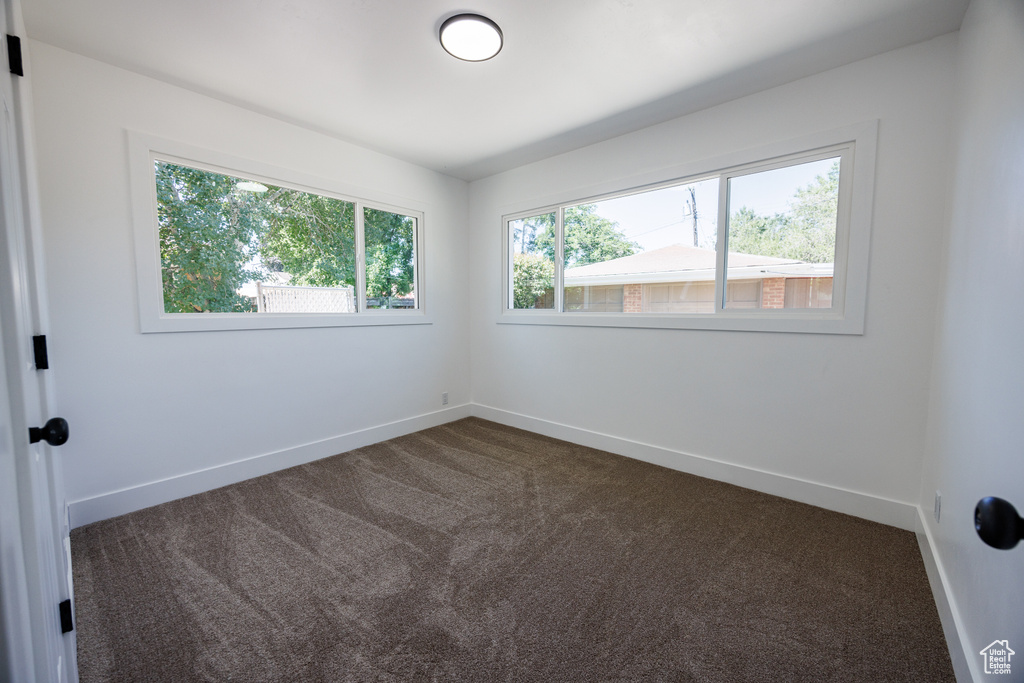Empty room featuring dark carpet