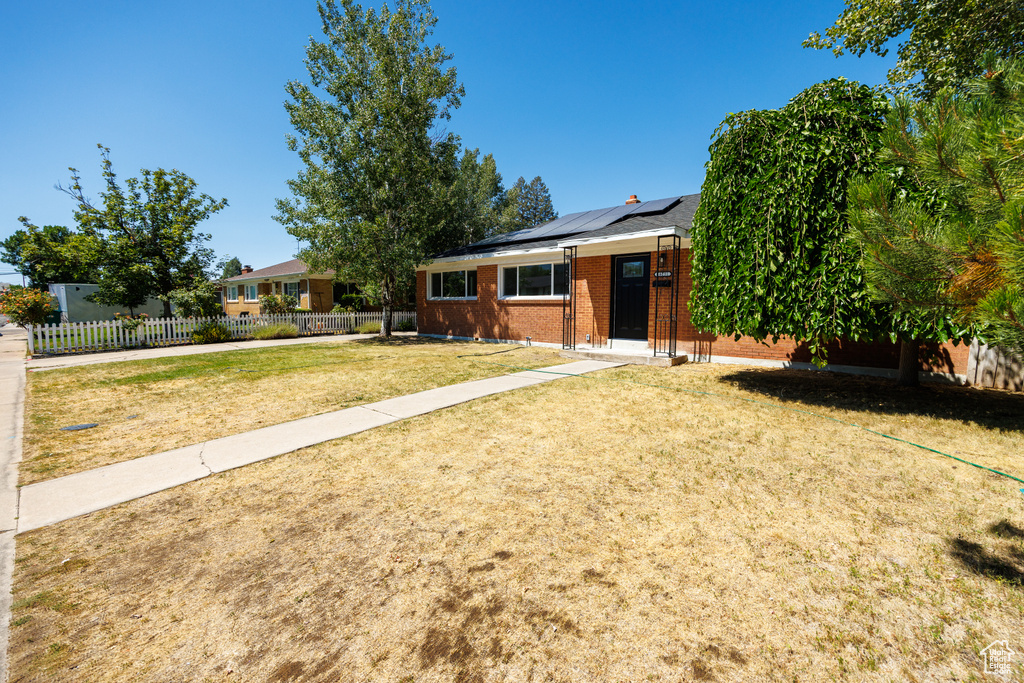 View of front of home featuring brick siding and solar panels