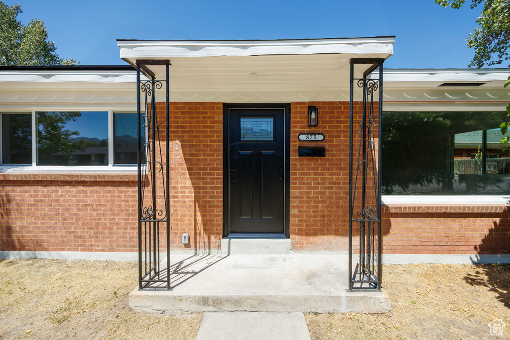 Doorway to property featuring brick siding
