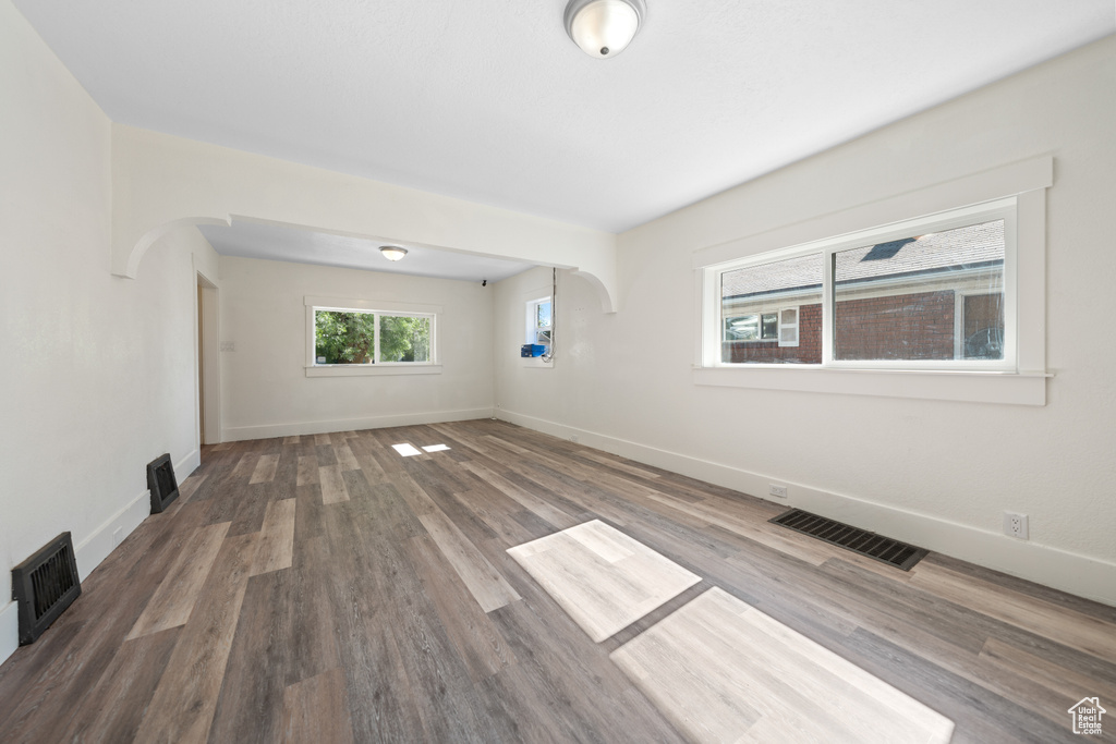 Spare room featuring wood finished floors and arched walkways