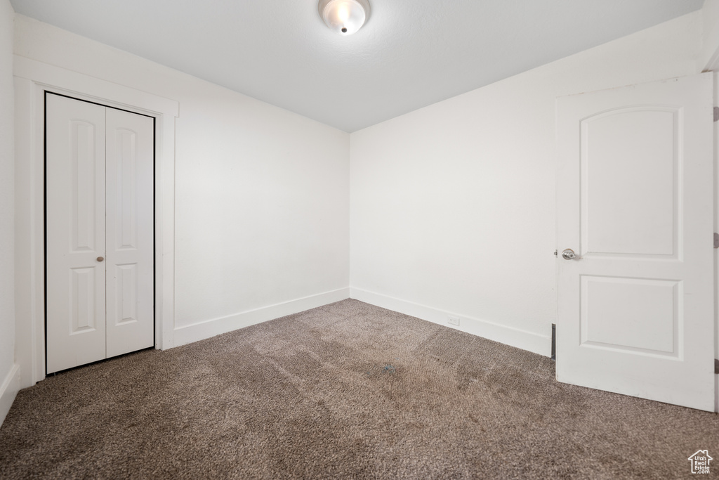 Unfurnished bedroom with carpet and a closet