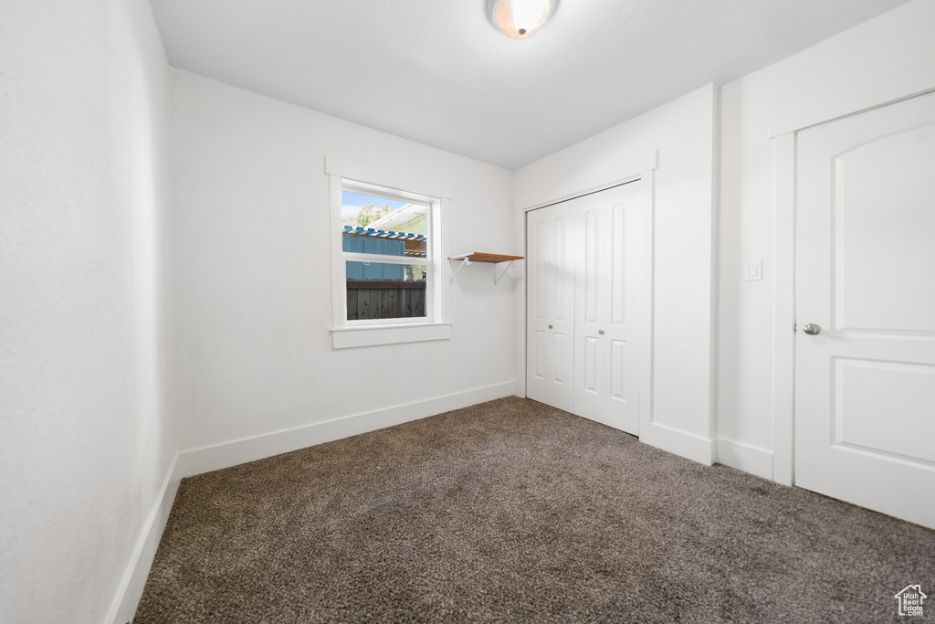 Unfurnished bedroom with carpet and a closet
