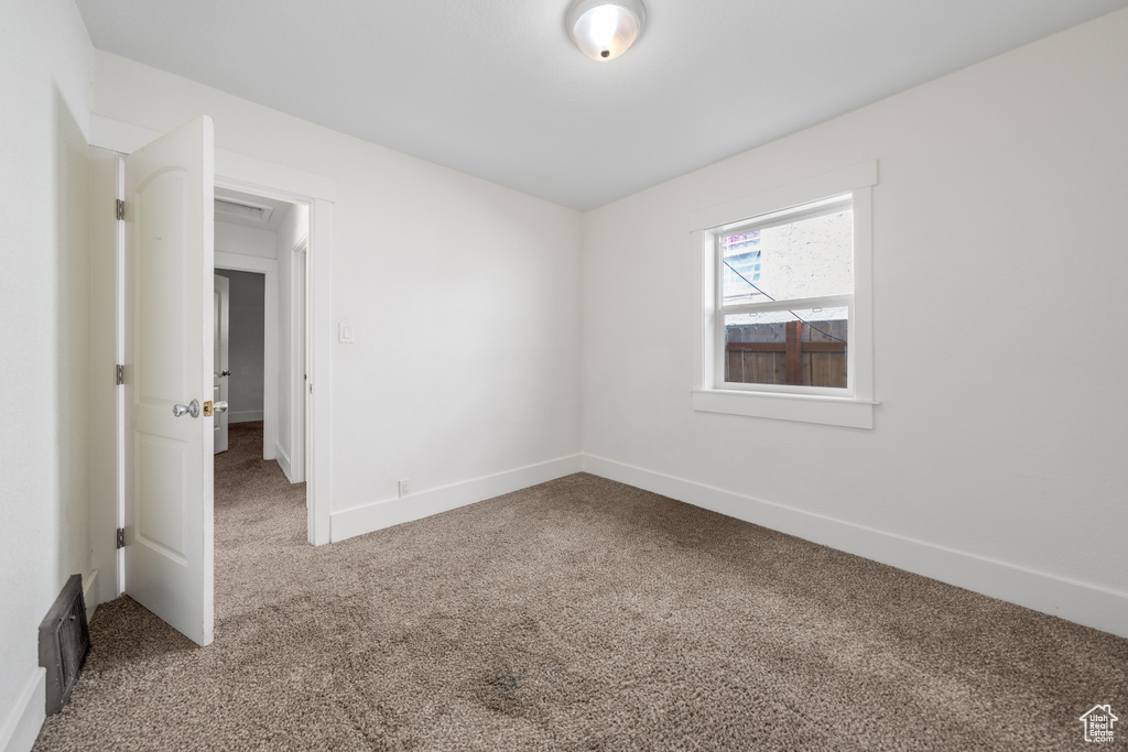 Carpeted spare room with baseboards