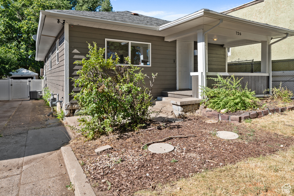 View of front of property with a gate and roof with shingles