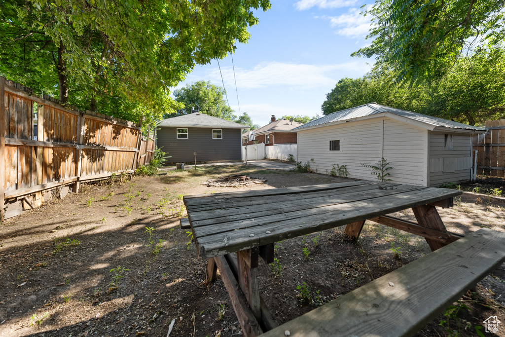 Fenced backyard featuring a deck and an outbuilding