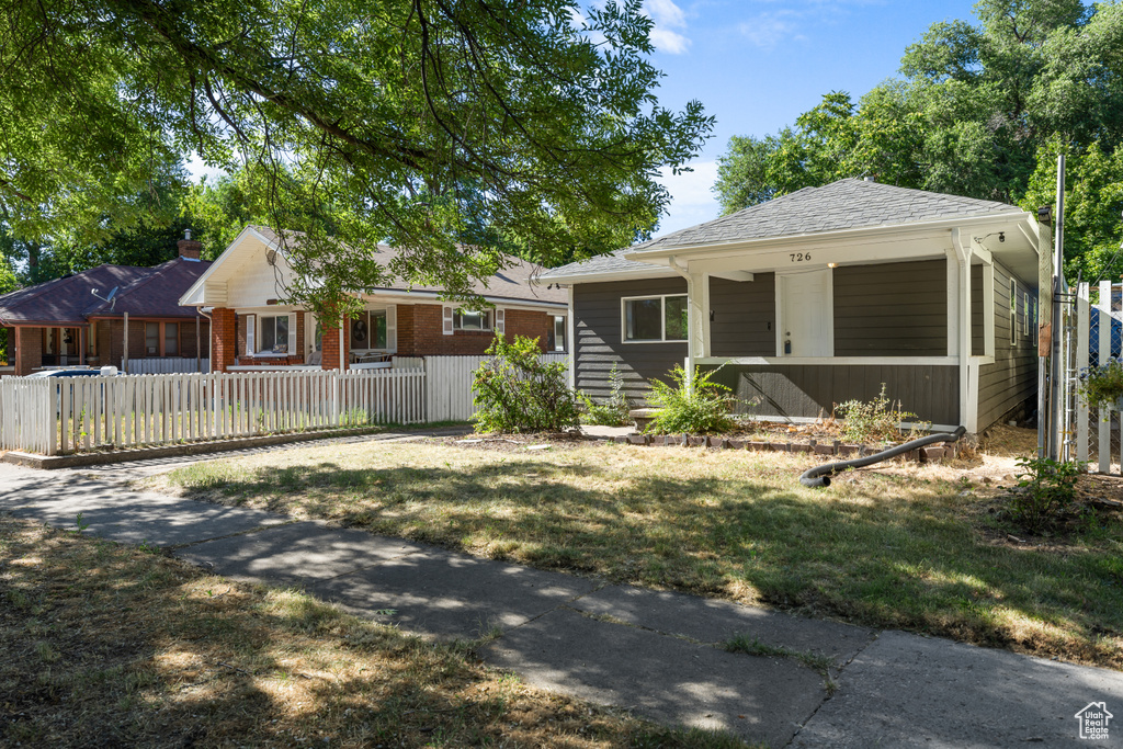 View of front of property with a fenced front yard and a porch
