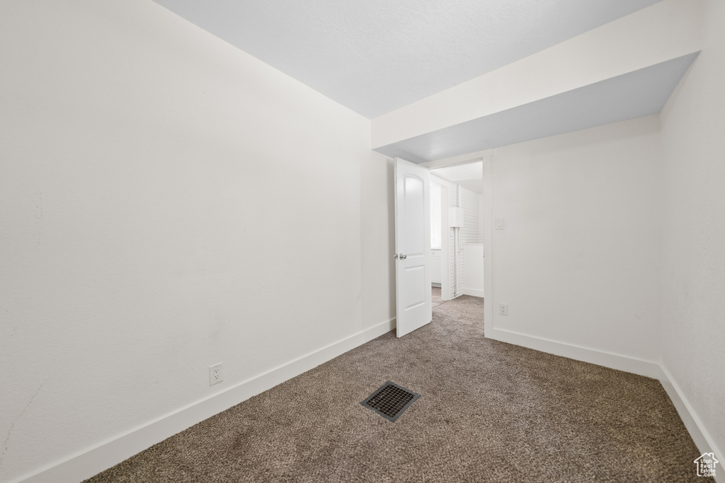 Empty room with carpet and baseboards