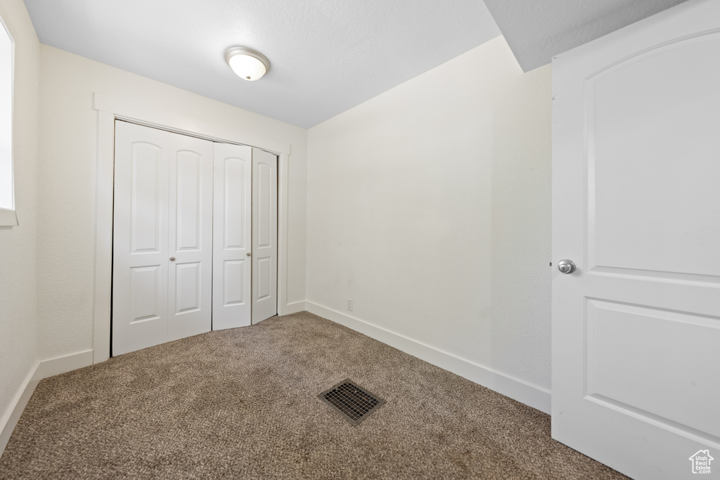 Unfurnished bedroom with carpet flooring and a closet