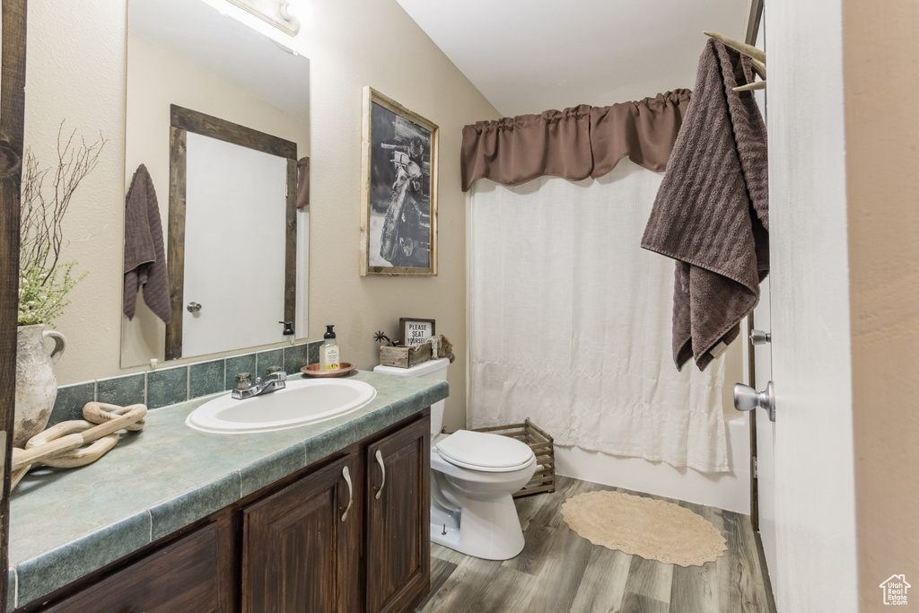Bathroom with vanity, wood finished floors, and shower / tub combo