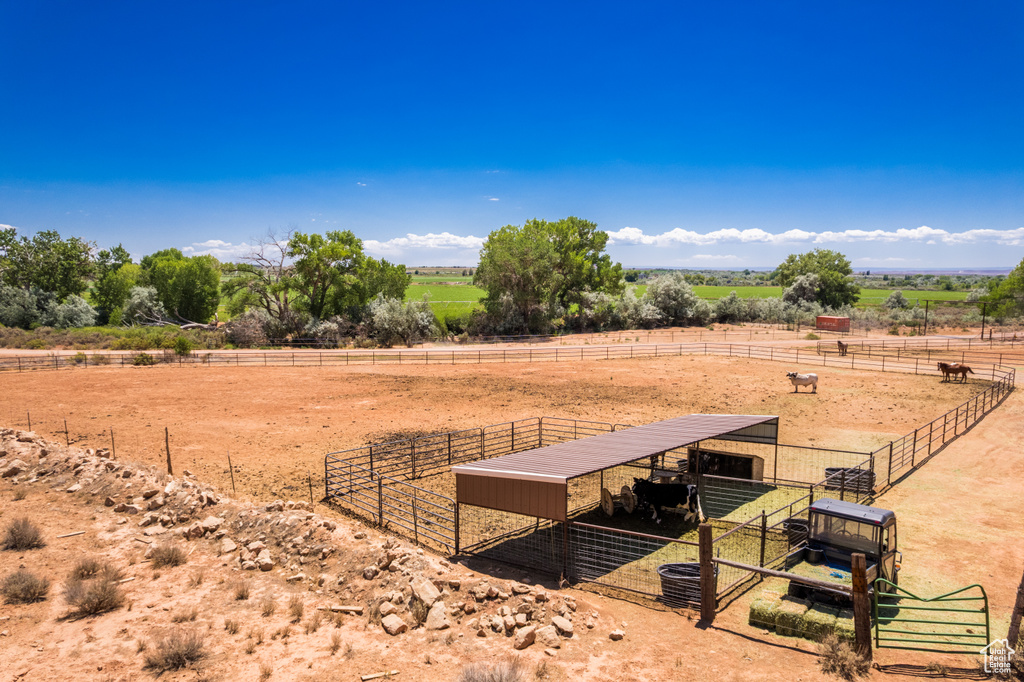 View of yard featuring a view of rural / pastoral area, an exterior structure, and an outdoor structure
