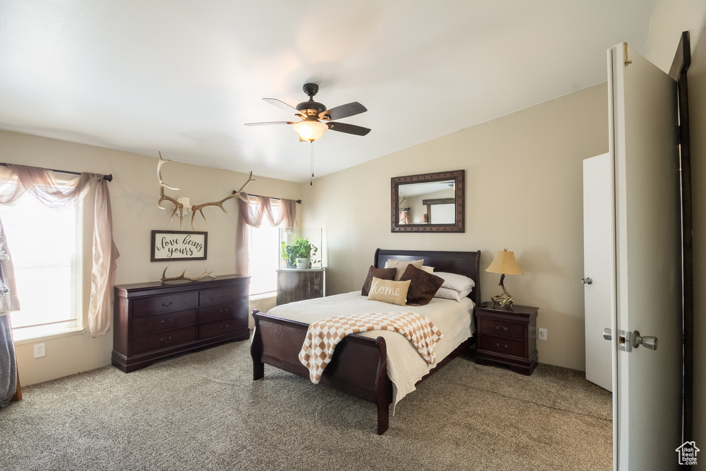 Carpeted bedroom featuring a ceiling fan