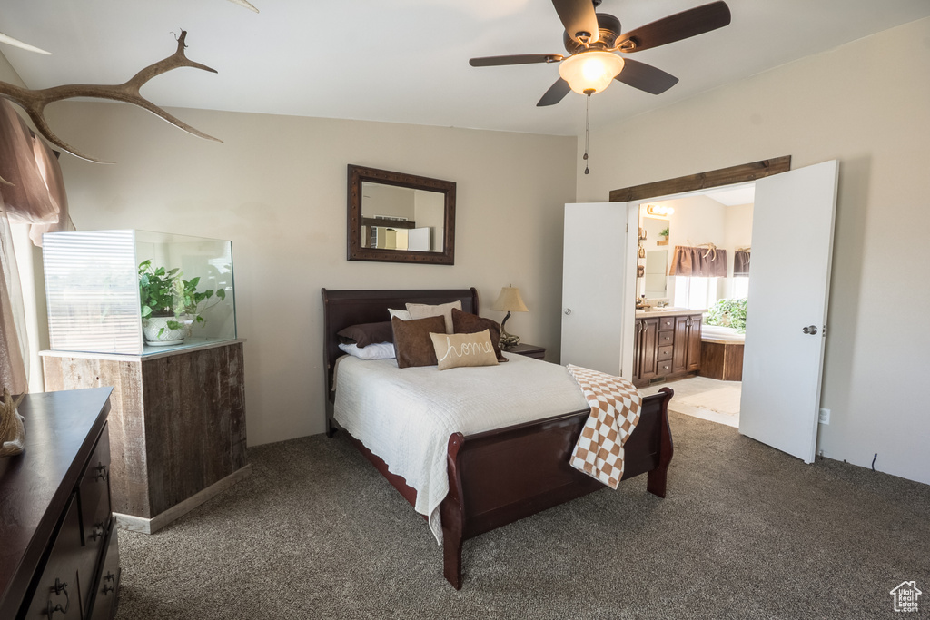 Bedroom with dark carpet, ensuite bath, and ceiling fan