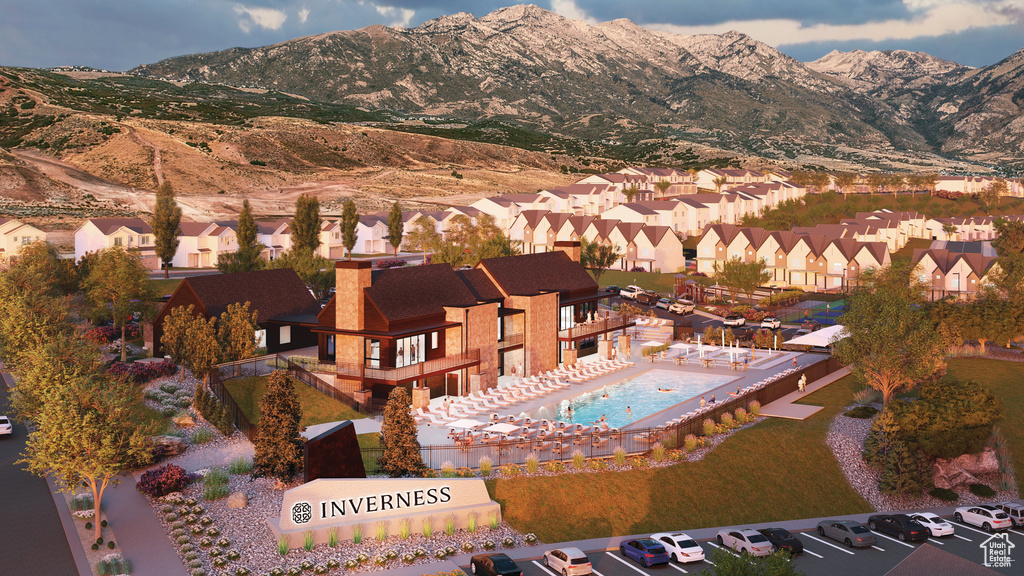 Aerial view of residential area featuring a mountain backdrop and a pool