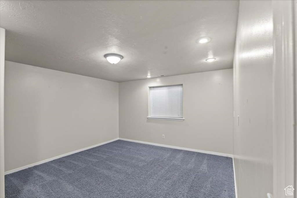 Unfurnished room featuring dark carpet, a textured ceiling, and recessed lighting