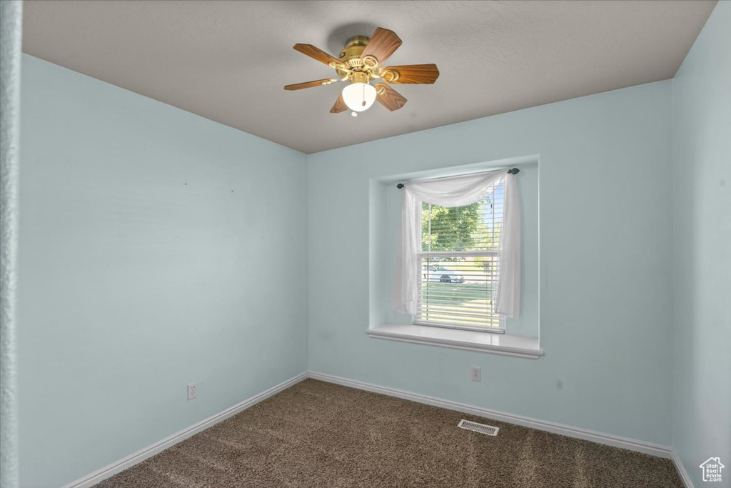 Spare room featuring carpet flooring and ceiling fan