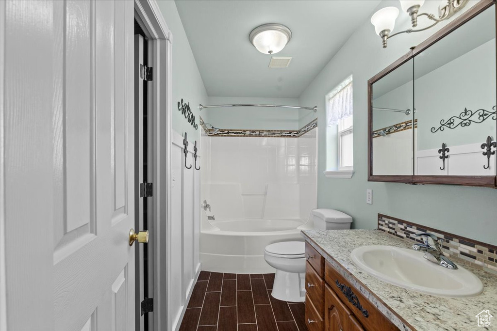 Bathroom featuring vanity, tub / shower combination, and wood finish floors