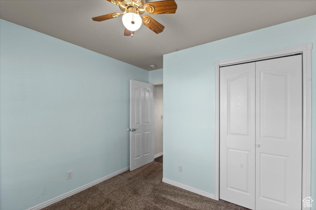 Unfurnished bedroom featuring carpet, a closet, and a ceiling fan