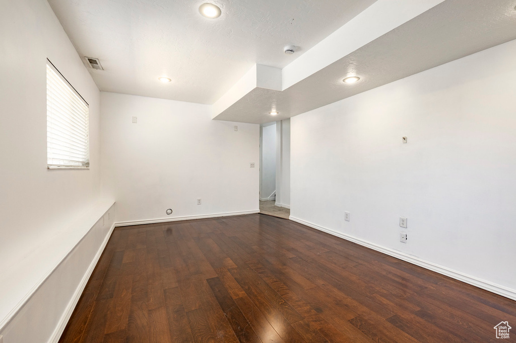 Empty room with wood finished floors, a smoke detector, and recessed lighting
