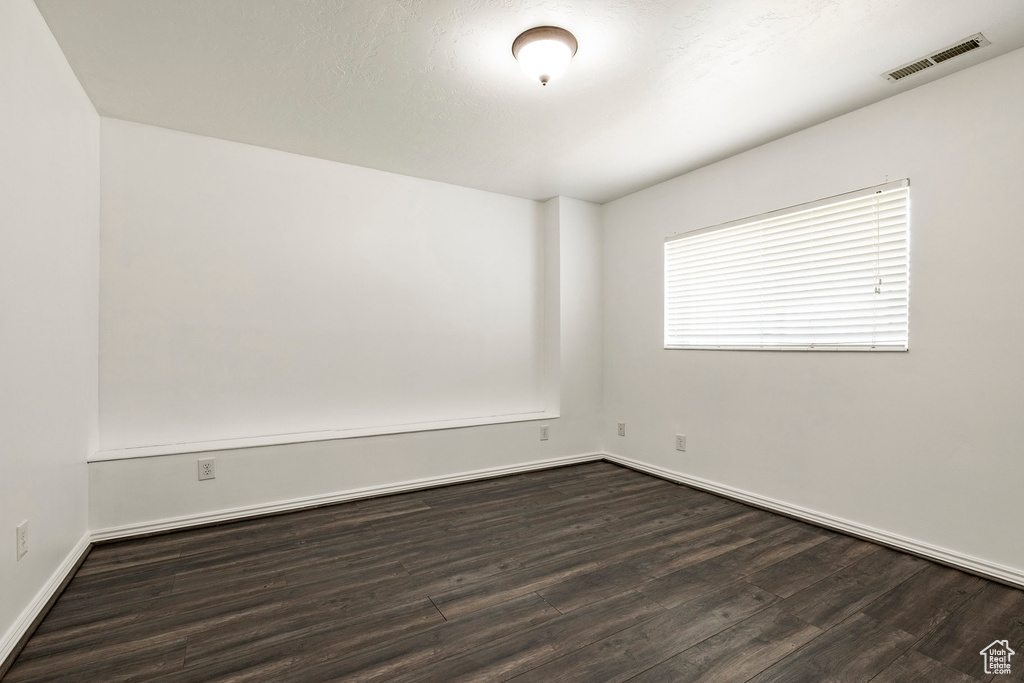 Empty room with dark wood-style floors and baseboards
