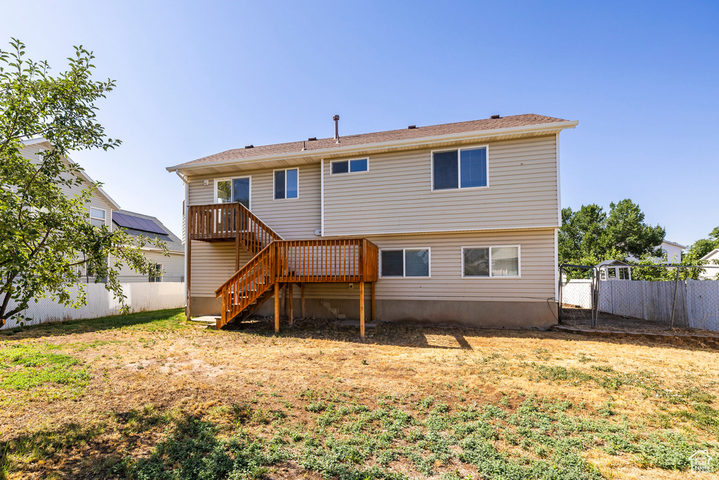 Back of house with a fenced backyard and stairway