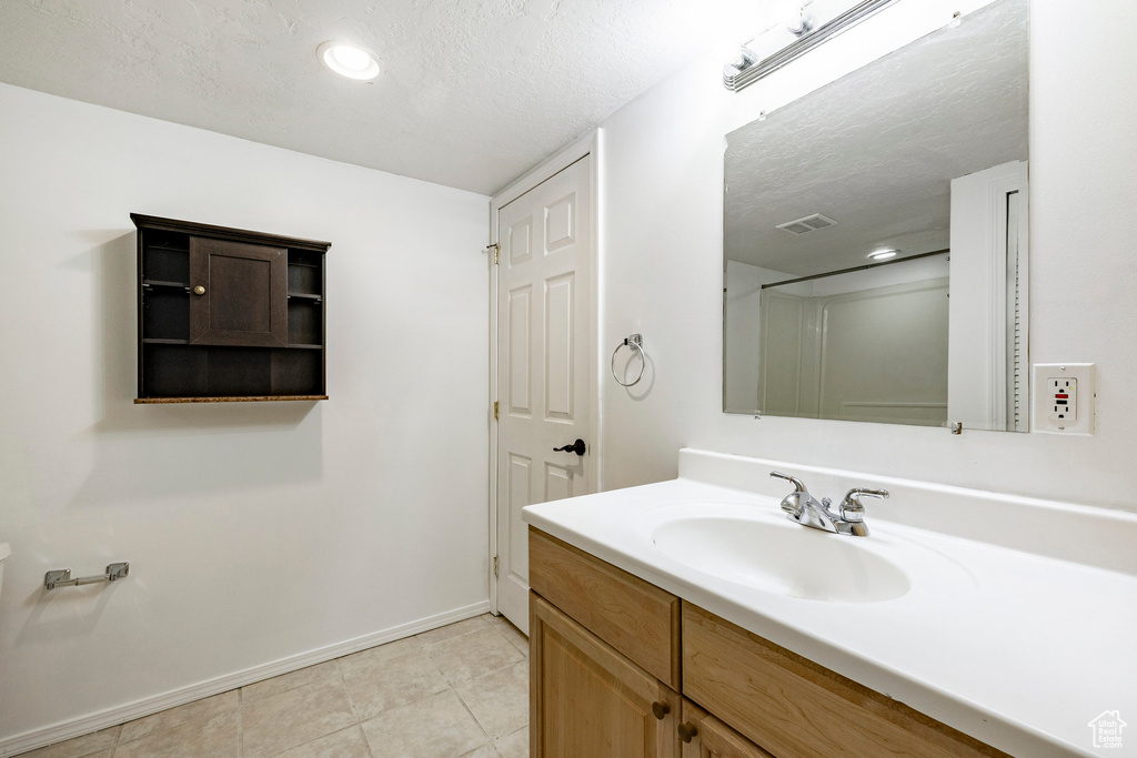 Bathroom with vanity, tile patterned floors, a textured ceiling, and recessed lighting