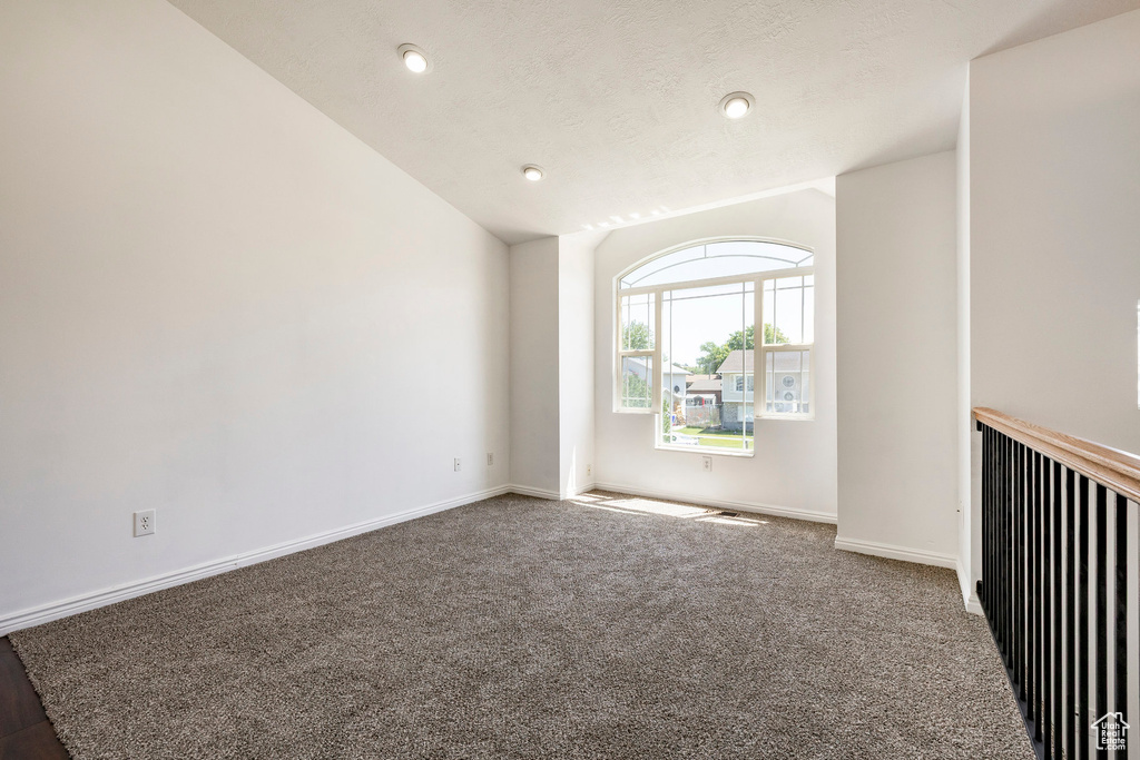 Unfurnished room with lofted ceiling, carpet floors, and recessed lighting