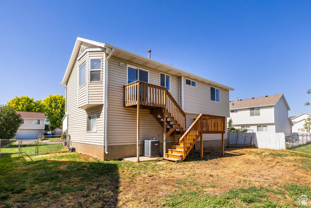 Back of house with a fenced backyard and stairs