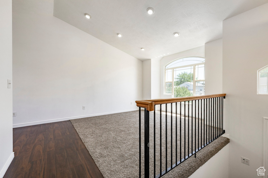 Corridor featuring wood finished floors, lofted ceiling, and recessed lighting