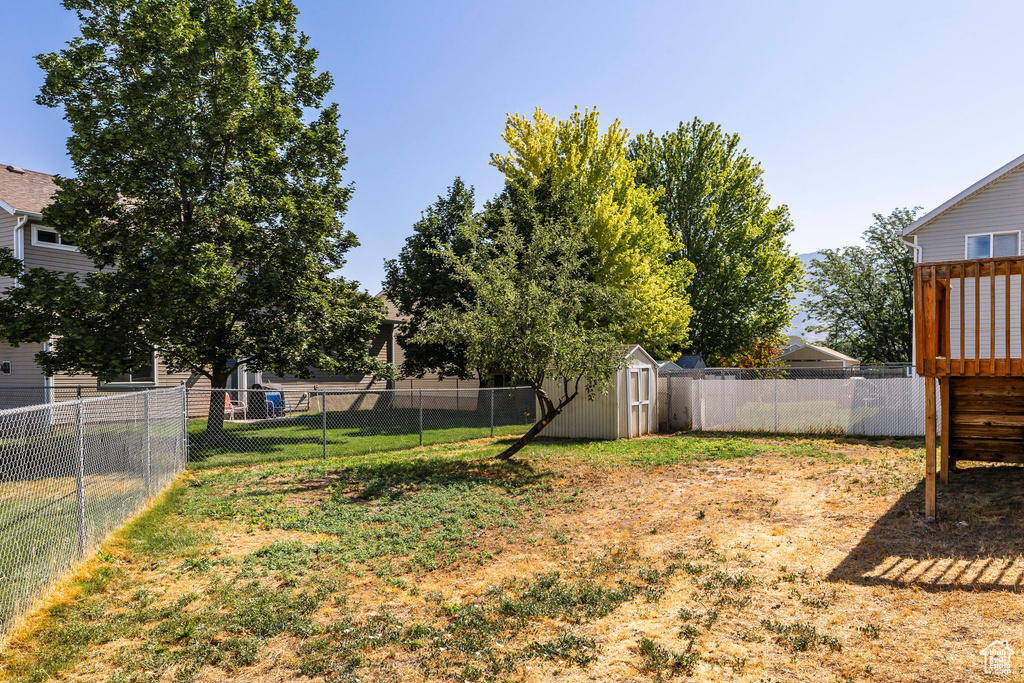 Fenced backyard featuring a storage unit
