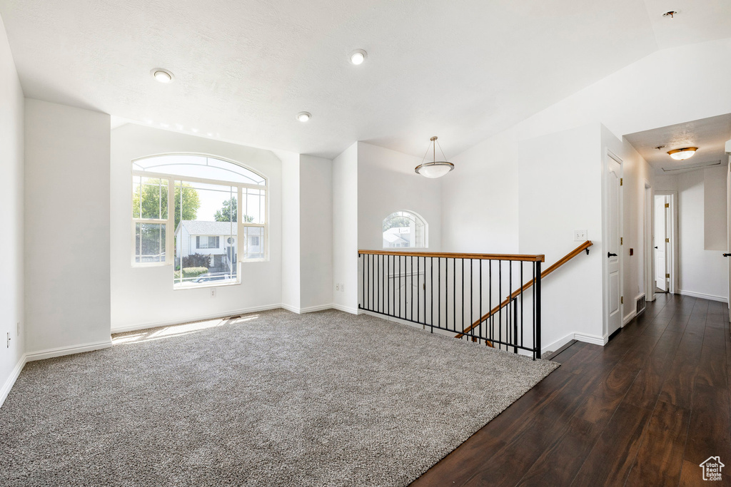 Unfurnished room with dark wood-style floors, attic access, vaulted ceiling, recessed lighting, and fire sprinkler in ceiling