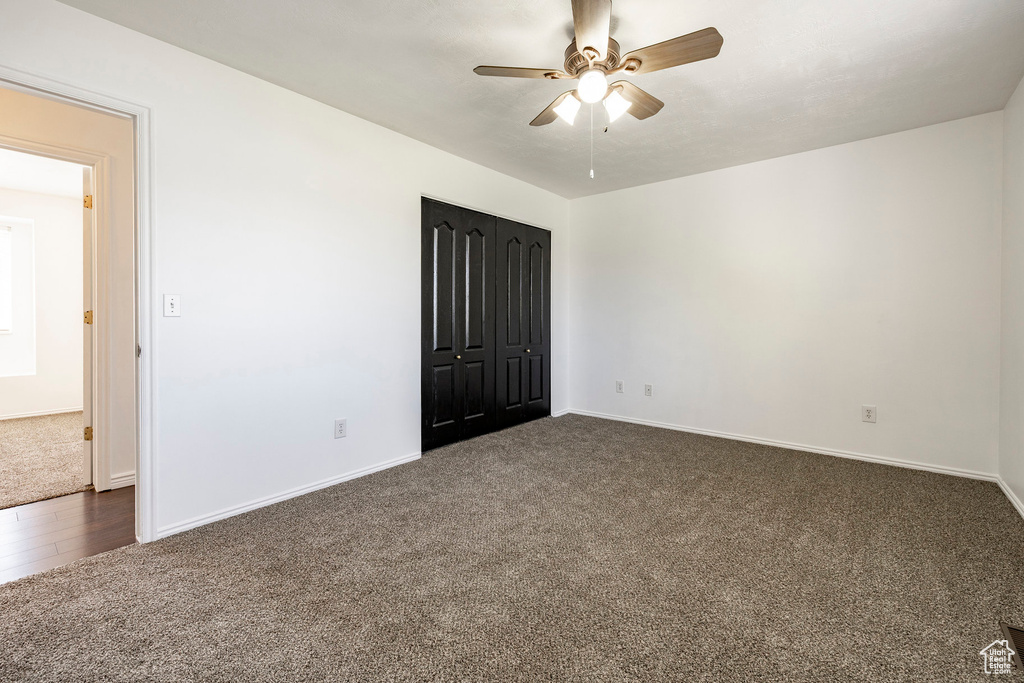 Spare room featuring dark carpet and ceiling fan