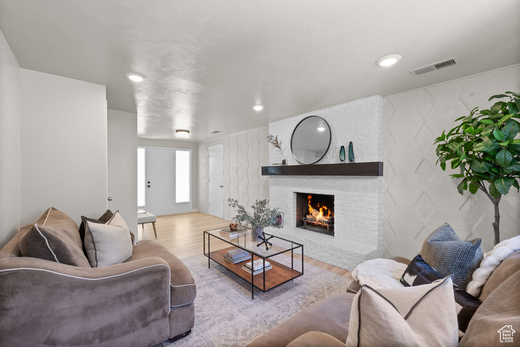 Living area with wood finished floors, a fireplace, and recessed lighting