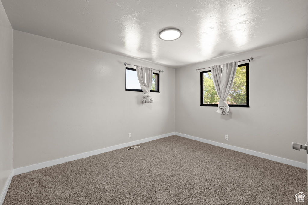 Carpeted empty room with baseboards