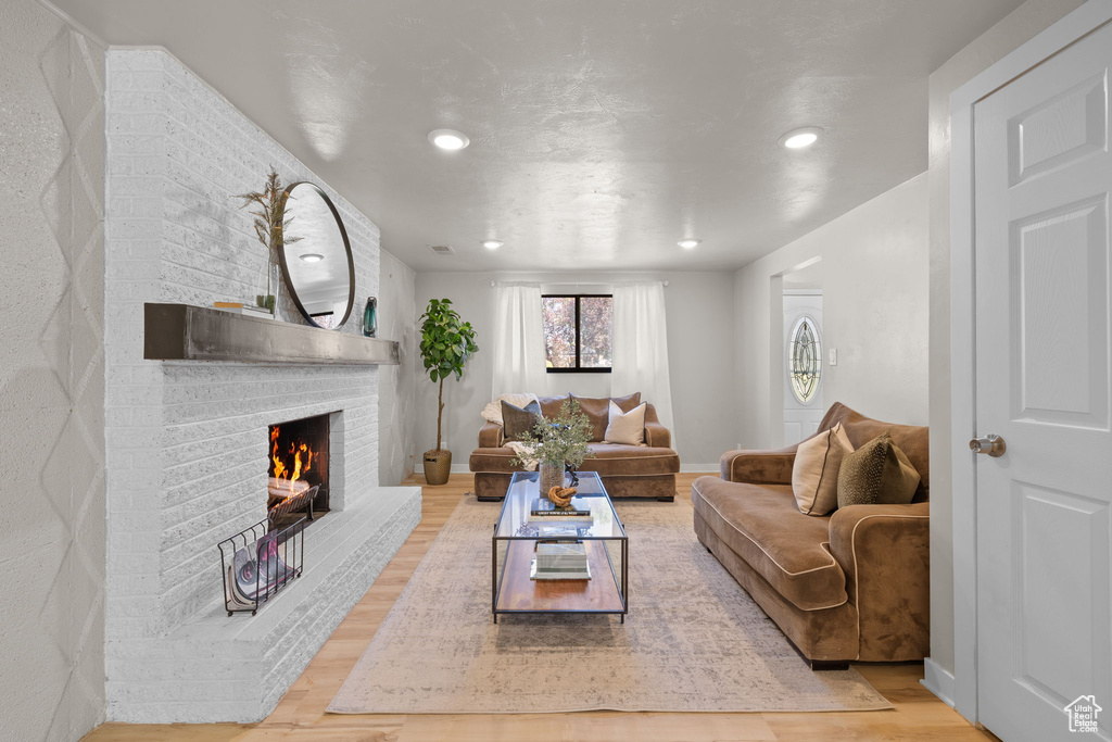 Living area featuring wood finished floors, a fireplace, and recessed lighting