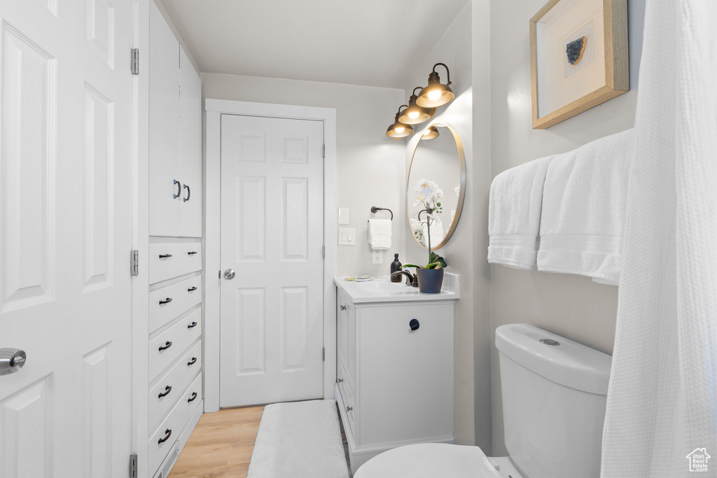 Full bath with vanity and wood finished floors