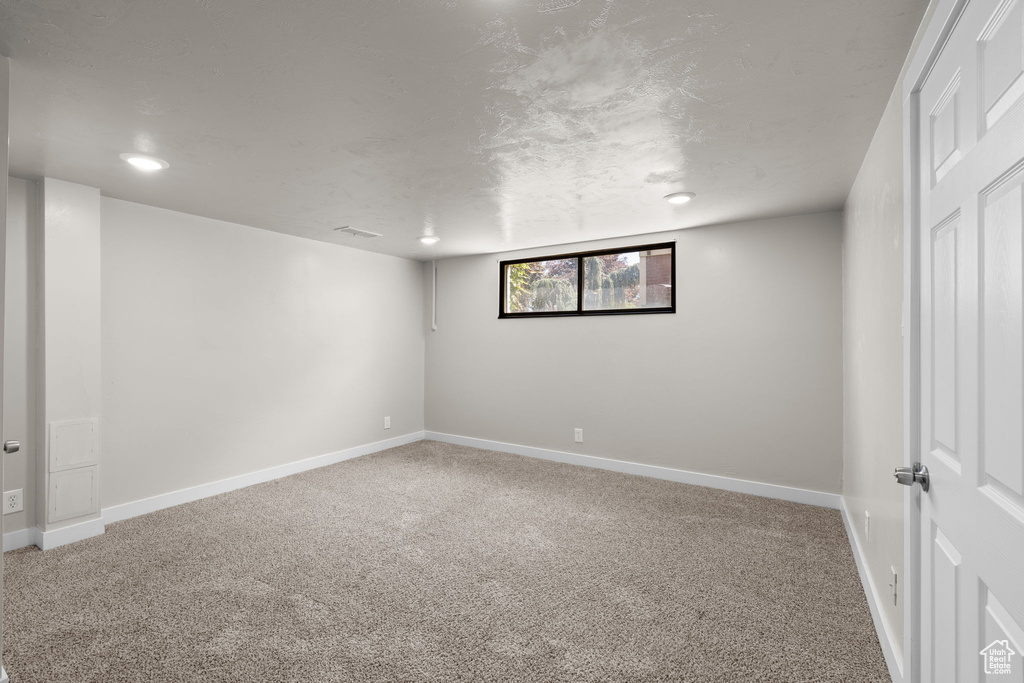 Carpeted spare room with baseboards and recessed lighting