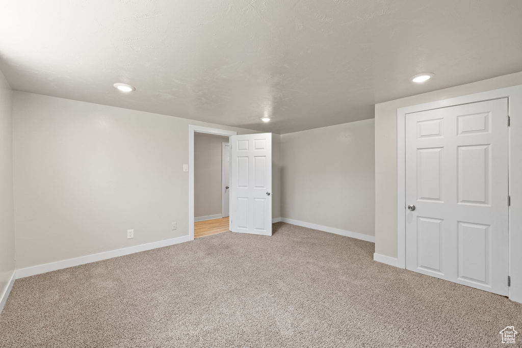 Basement with light carpet and recessed lighting