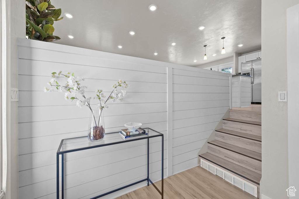 Hall featuring light wood-style flooring, stairs, and recessed lighting