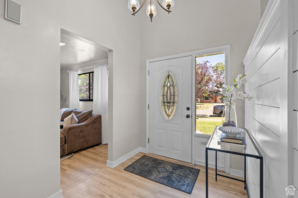 Entrance foyer featuring a chandelier, wood finished floors, and a high ceiling